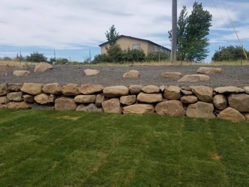 Boulder Retaining Wall with desert landscaping.